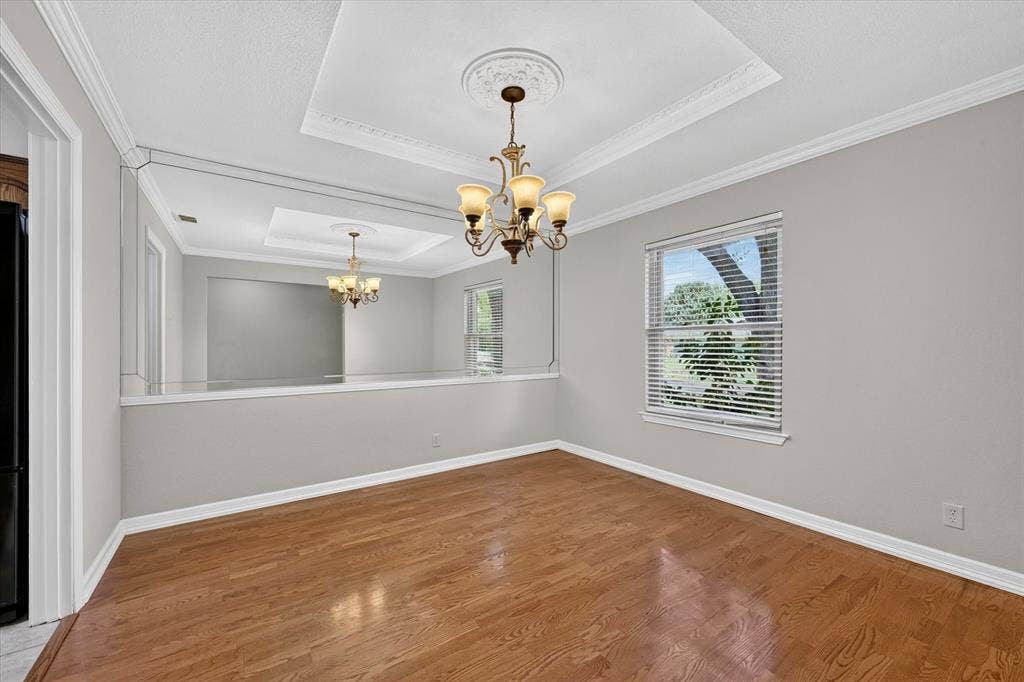 3310 Raintree Drive, Plano, TX 75074 Formal dining room featuring tray ceilings, crown molding and wood flooring