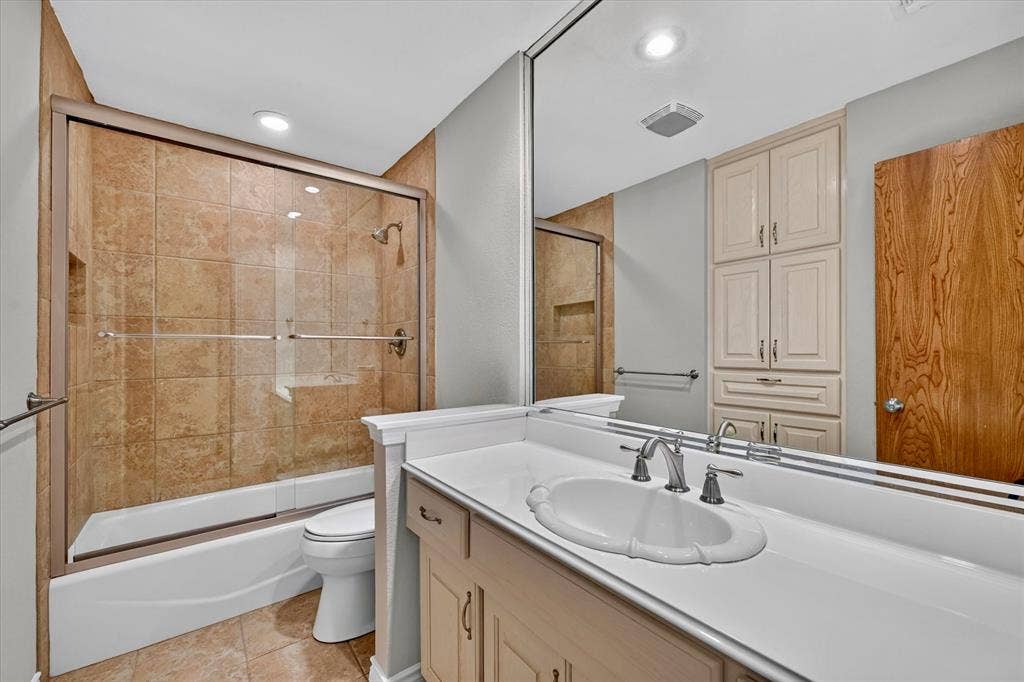 3310 Raintree Drive, Plano, TX 75074 Updated secondary bath with custom tile surround, glass enclosure, and modern fixtures