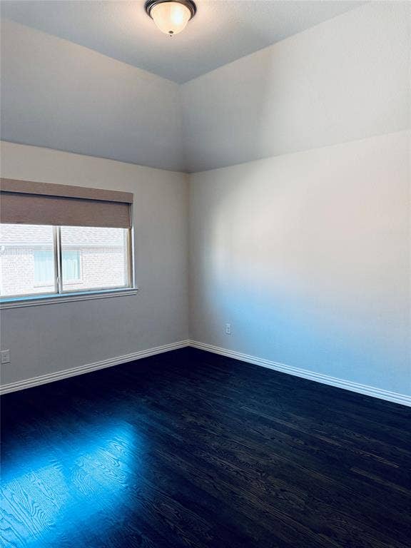 2455 Cathedral Drive, Richardson, TX 75080 2nd Spacious bedroom featuring dark wood-finish flooring, crisp white walls, and a recessed window with a neutral roller shade