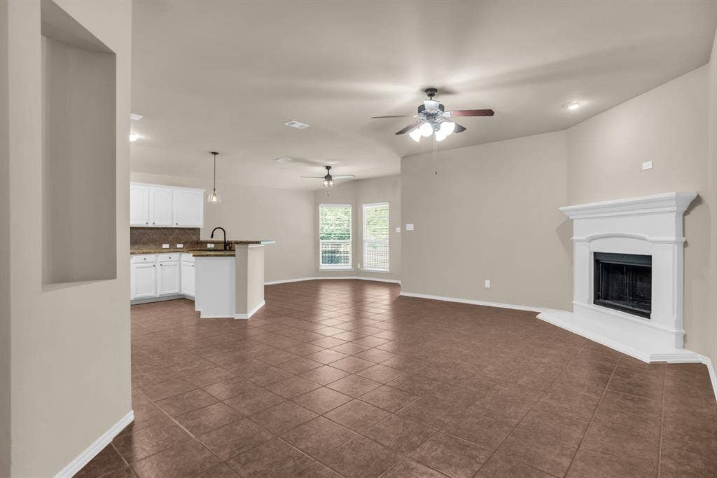 805 Andrews Court, Anna, TX 75409 Expansive open living area featuring tile flooring, a fireplace with a white mantel, and ceiling fans