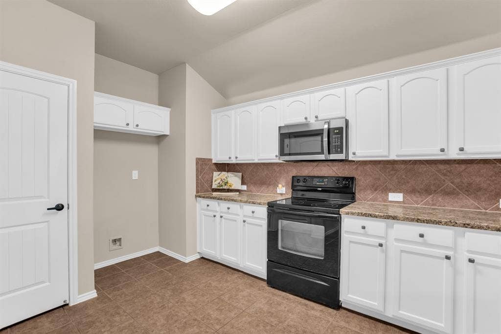 805 Andrews Court, Anna, TX 75409 Kitchen featuring white cabinetry, stone-finish countertops, stainless steel microwave, black electric range, and tile flooring