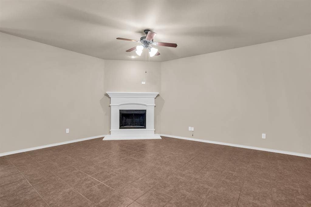 805 Andrews Court, Anna, TX 75409 Spacious living room featuring a decorative fireplace with a white mantel, tile flooring, and a ceiling fan