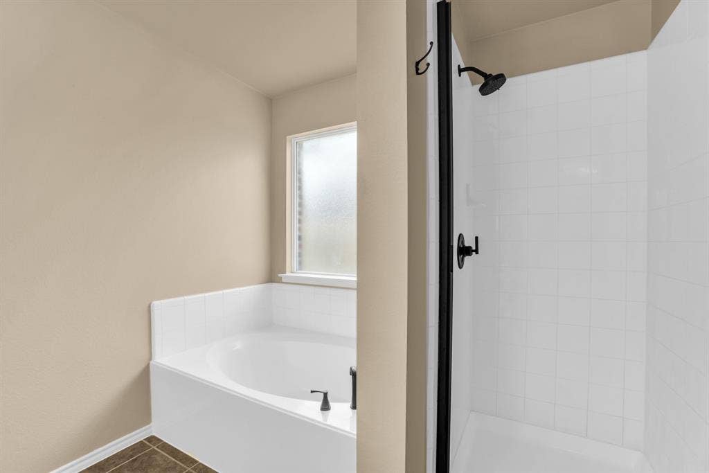 805 Andrews Court, Anna, TX 75409 Built-in soaking tub with tile surround, frosted window, and black fixtures