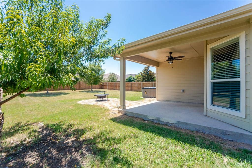 805 Andrews Court, Anna, TX 75409 Covered patio with a ceiling fan, concrete flooring, and an expansive lawn featuring mature trees
