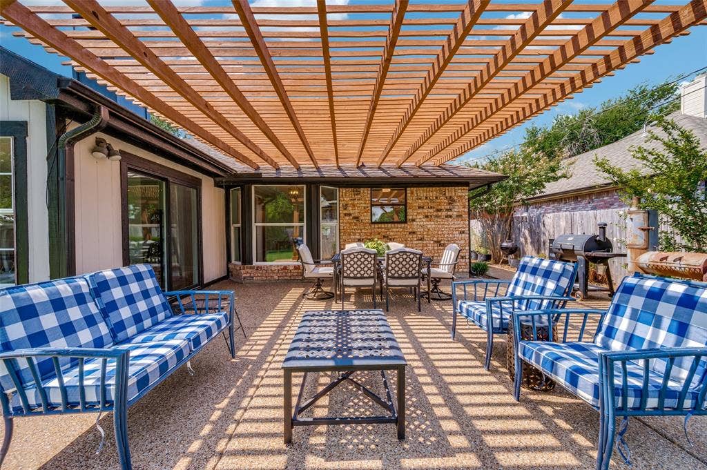 8420 Christie Drive, Frisco, TX 75033 Expansive patio featuring an open-slat pergola, exposed aggregate concrete flooring, and direct access to interior spaces through sliding glass doors