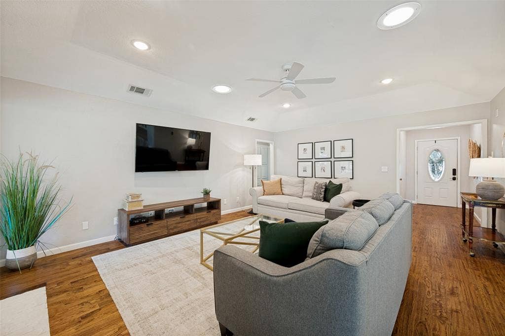 8420 Christie Drive, Frisco, TX 75033 Living space featuring tall ceilings, lightly scrapped wood flooring, ceiling fan, and a white paneled entry door with oval glass insert