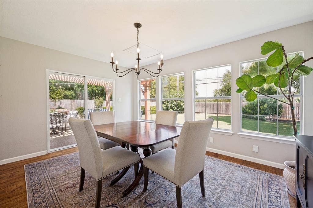 8420 Christie Drive, Frisco, TX 75033 Formal Dining space featuring a classic chandelier and multiple views of landscaped yard and patio. Depending on your lifestyle, this room can easily be repurposed.