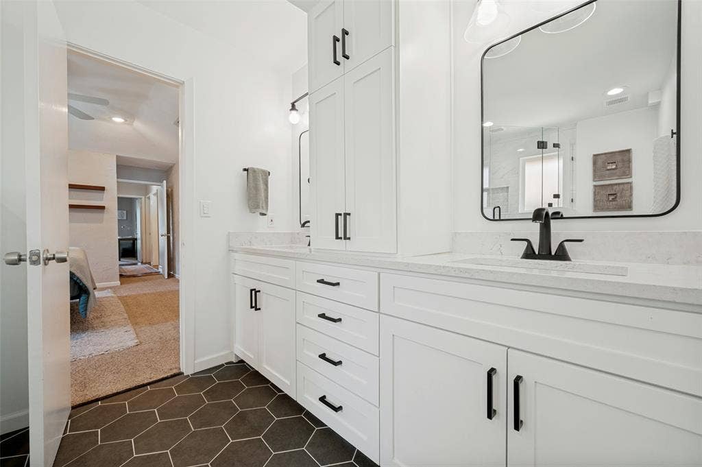 8420 Christie Drive, Frisco, TX 75033 Bathroom featuring a dual vanity with white cabinetry and black hardware