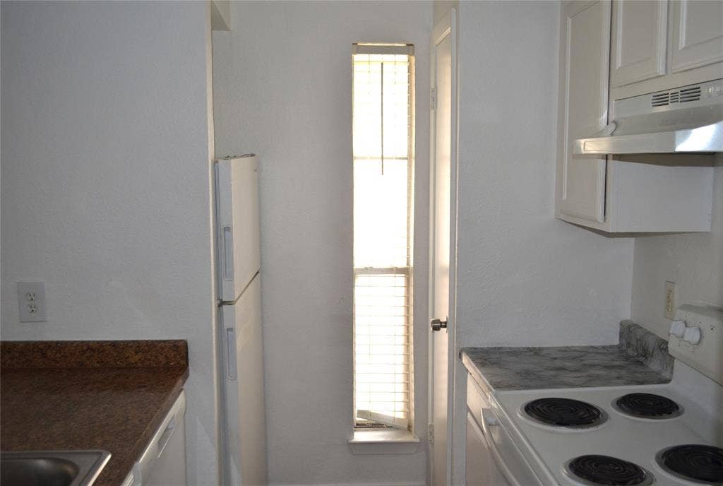 5500 Boca Raton Boulevard, #426, Fort Worth, TX 76112 Kitchen featuring white cabinetry, a built-in refrigerator, and a narrow window with blinds