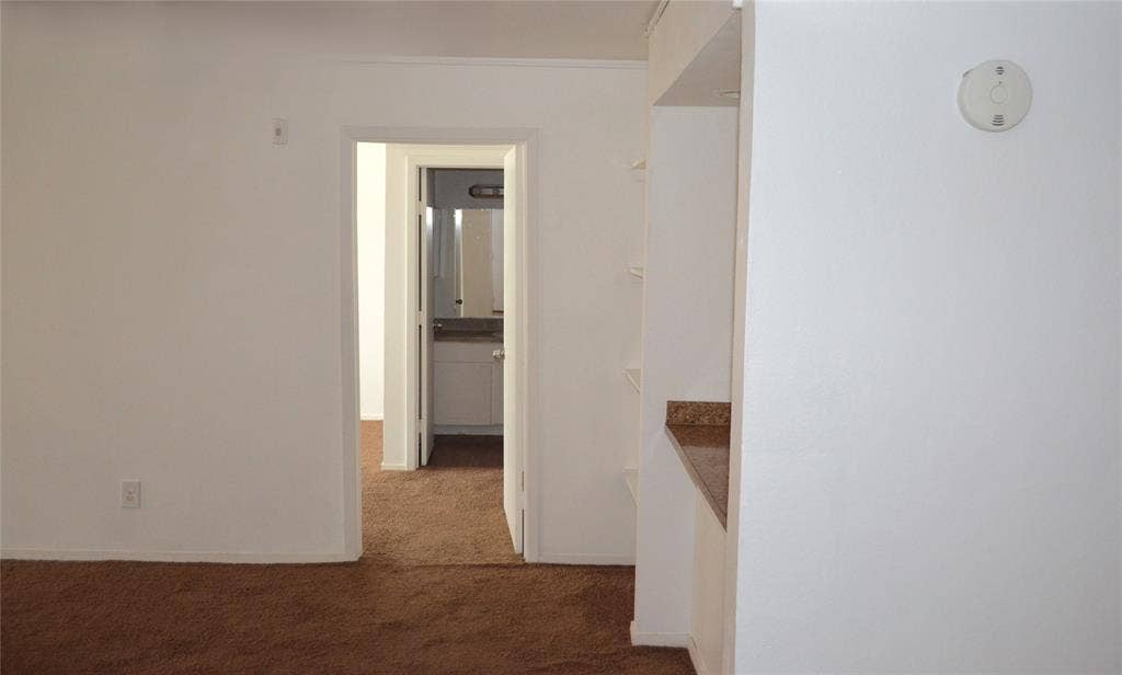 5500 Boca Raton Boulevard, #426, Fort Worth, TX 76112 Neutral wall color, brown carpet flooring, built-in shelving, and a countertop surface