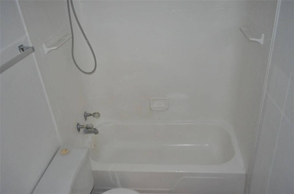 5500 Boca Raton Boulevard, #426, Fort Worth, TX 76112 White bathtub with integrated shower, chrome fixtures, and a wall-mounted shower head with hose