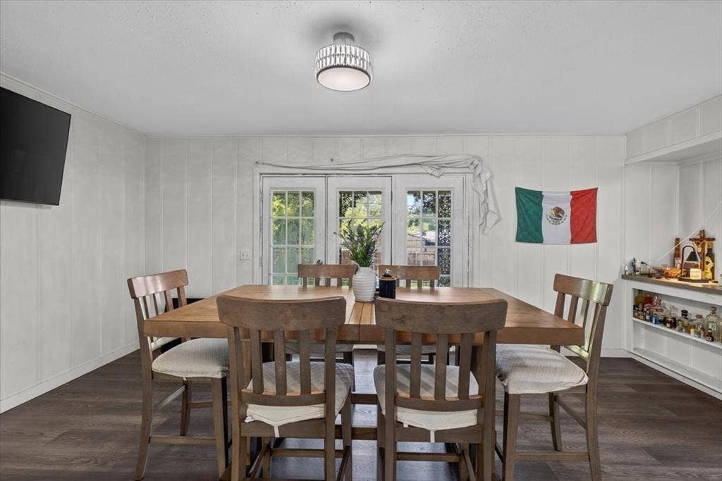 925 Maryland Drive, Athens, TX 75751 Dining area with wood-finish flooring, white paneling, and a contemporary ceiling light fixture
