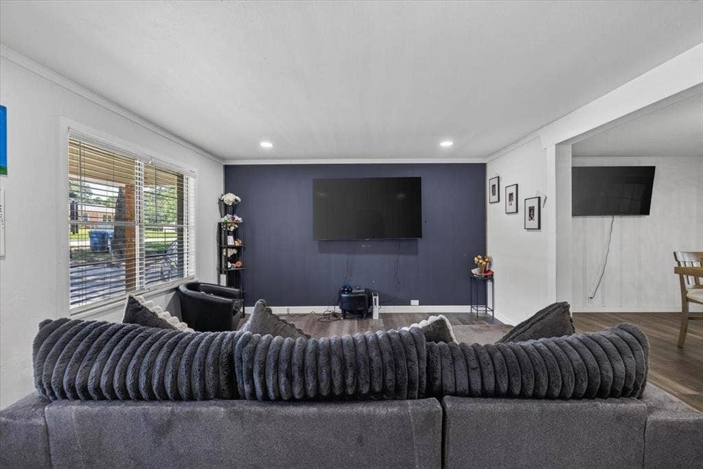 925 Maryland Drive, Athens, TX 75751 Open-concept living space featuring wood-finish flooring, recessed lighting, and a prominent accent wall
