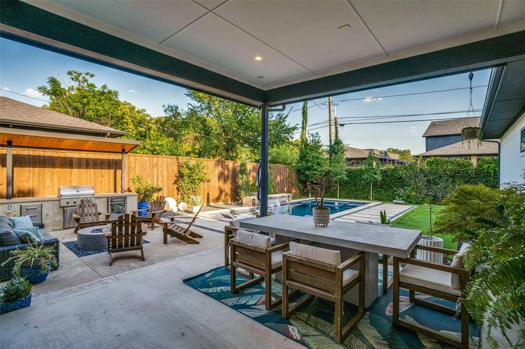 3766 Manana Drive, Dallas, TX 75220 8' board on board fenced backyard with outdoor dining area, an outdoor living space with a fire pit, a patio area, and area for grilling and gorgeous salt water pool/spa.