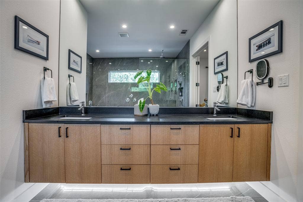 3766 Manana Drive, Dallas, TX 75220 Quartz counter floating vanity has under cabinet lighting and double under mounted sink.