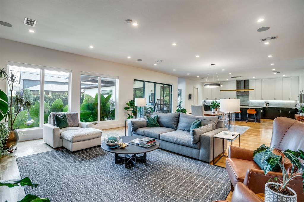 3766 Manana Drive, Dallas, TX 75220 Open concept living-dining-kitchen featuring large windows with a gorgeous view of the back yard. Electric blinds on windows allow ease of opening and closing without getting off the sofa.