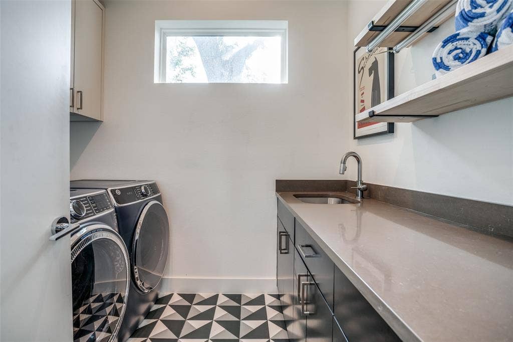 3766 Manana Drive, Dallas, TX 75220 Washroom featuring space for independent full sized washer and dryer, plenty of cabinet space, quartz countertop folding area, a window for natural light and tile patterned floors.