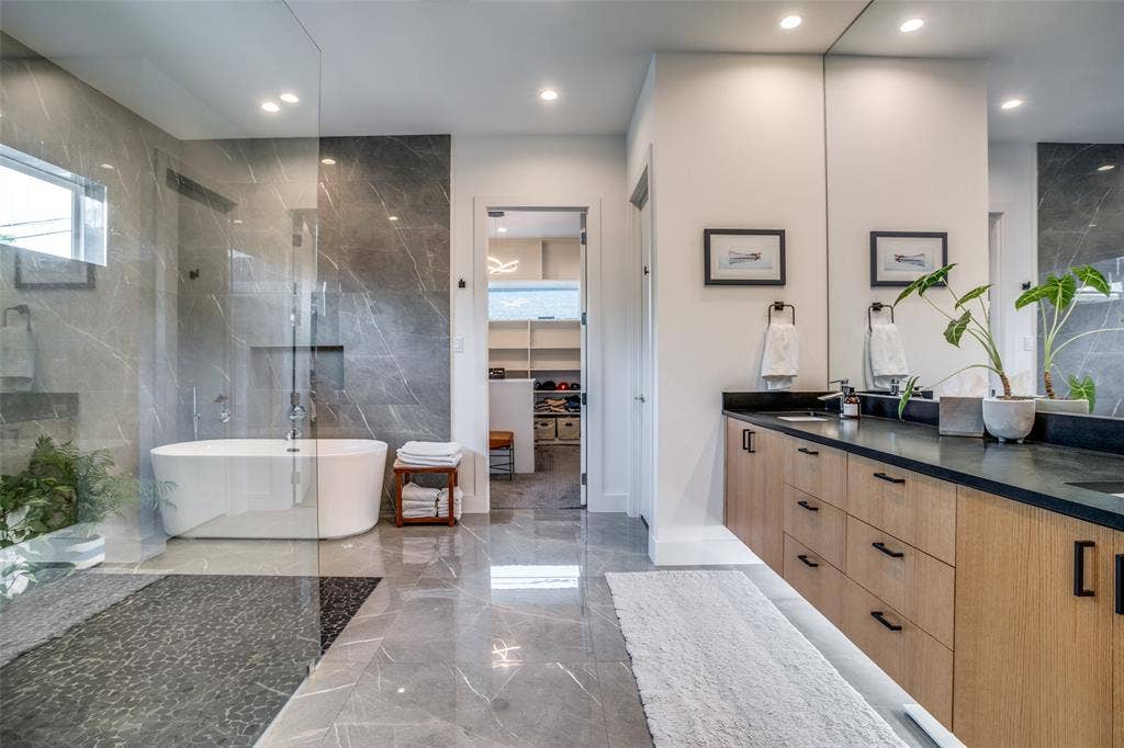 3766 Manana Drive, Dallas, TX 75220 Ensuite bathroom with marble tiled floors, a free standing vessel tub, a huge seamless walk in shower with a high window and stone tiled walls.