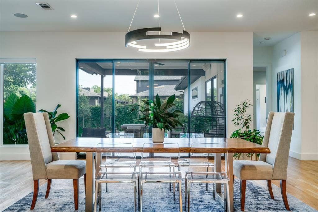 3766 Manana Drive, Dallas, TX 75220 Dining room with designer lighting and outdoor views from the full length sliding doors.