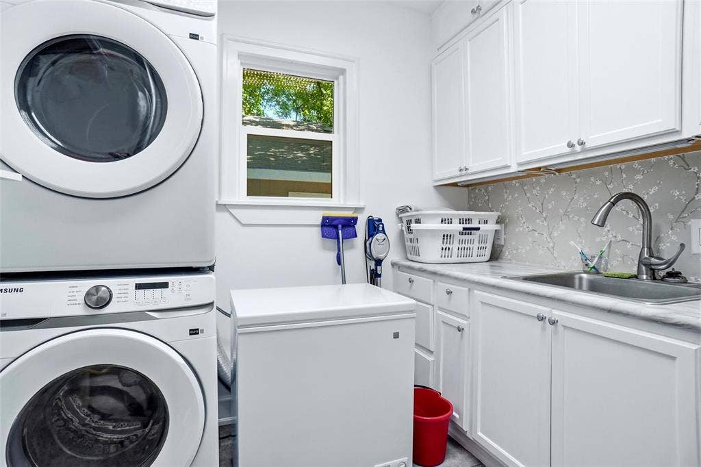 2306 Western Avenue, Fort Worth, TX 76107 Dedicated laundry space featuring a window, white cabinetry, a sink with a gooseneck faucet, light-toned countertop, and a decorative backsplash