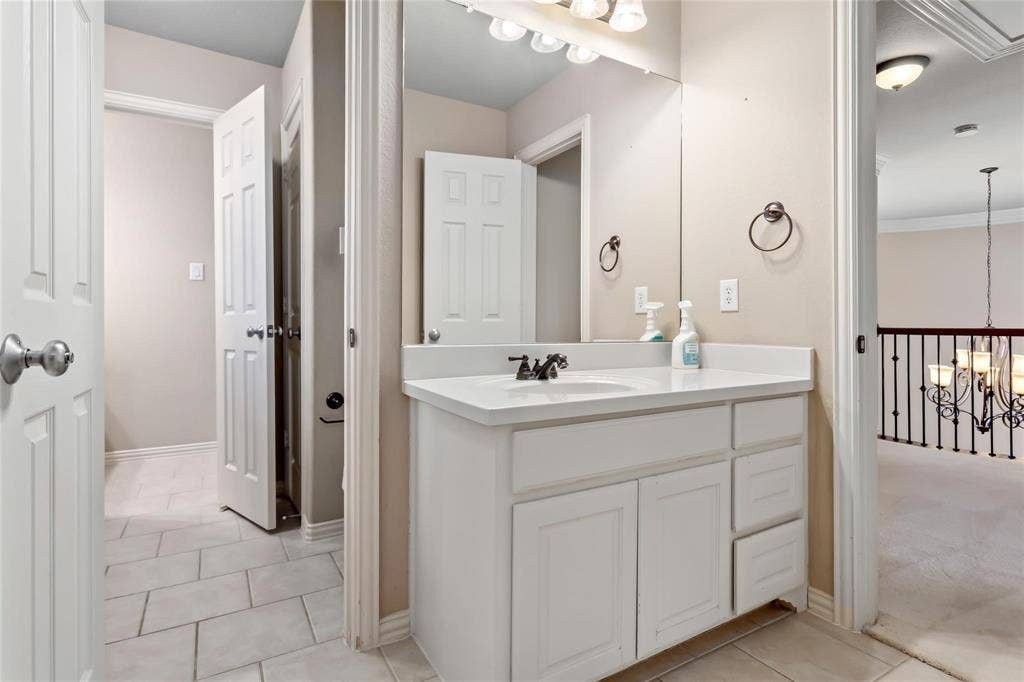 921 Pine Burst Drive, Allen, TX 75013 Bathroom vanity featuring a white countertop, integrated sink, and white cabinetry with both doors and drawers