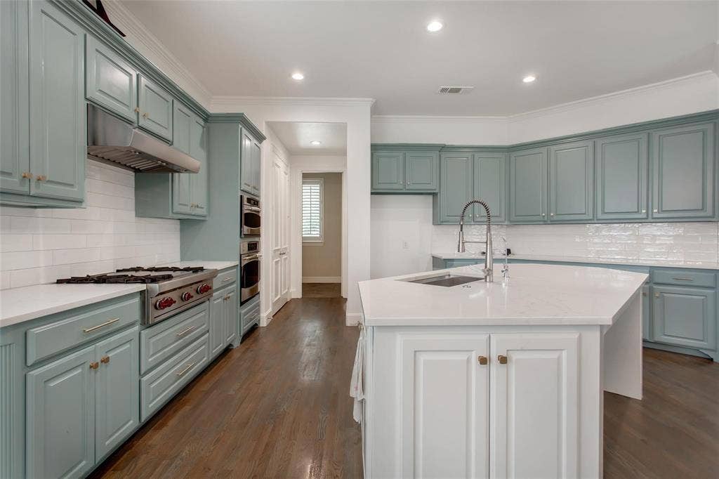 921 Pine Burst Drive, Allen, TX 75013 Spacious kitchen featuring light blue cabinetry, white countertops, stainless steel appliances, and a central island with an integrated sink