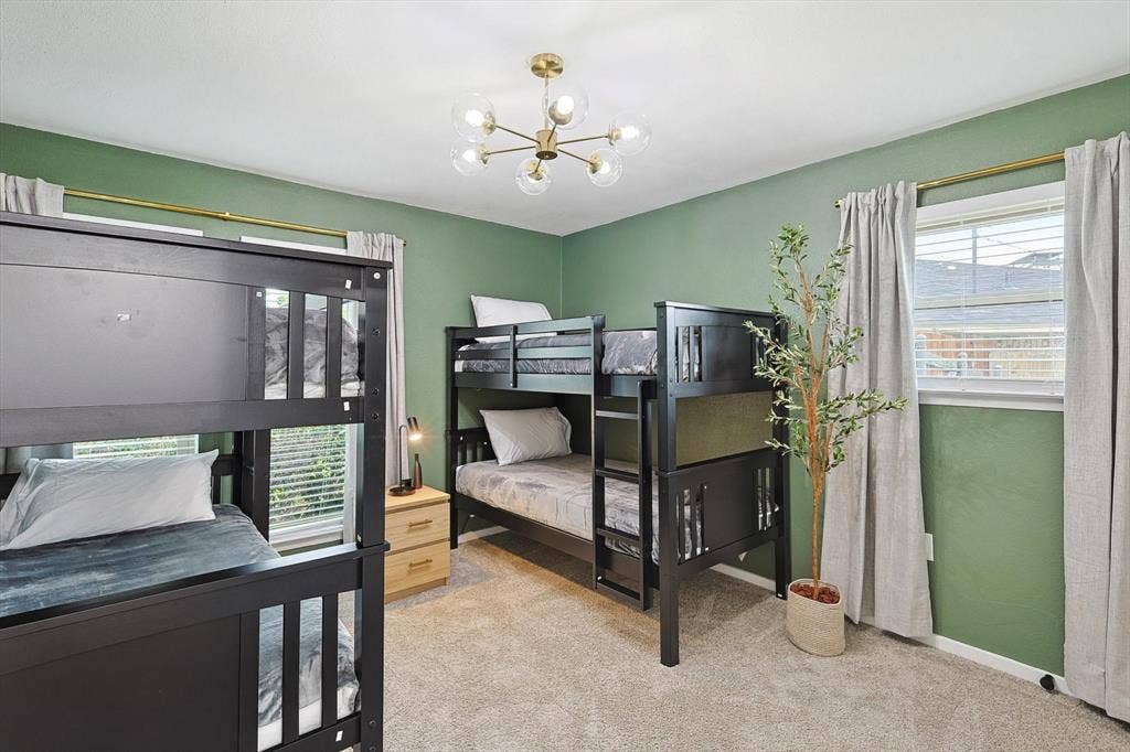 1208 Mayleaf Drive, Irving, TX 75060 Spacious room featuring two dark-finish bunk beds, light green wall paint, and carpet flooring