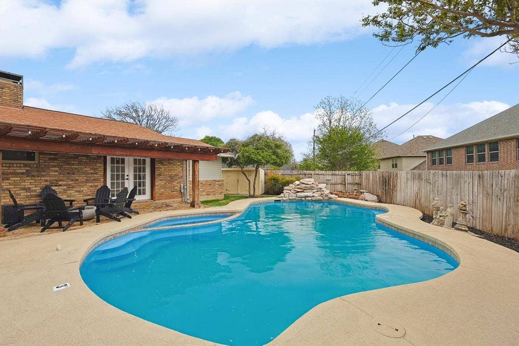 1208 Mayleaf Drive, Irving, TX 75060 Freeform swimming pool with integrated spa and rock waterfall feature