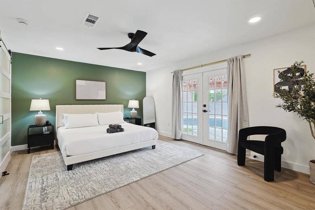 1208 Mayleaf Drive, Irving, TX 75060 Floor-to-ceiling French doors provide access to the exterior, complemented by light wood-finish flooring throughout