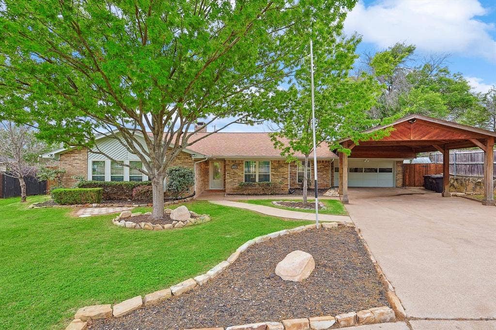 1208 Mayleaf Drive, Irving, TX 75060 Brick exterior residence featuring a covered carport, attached garage, and a concrete driveway
