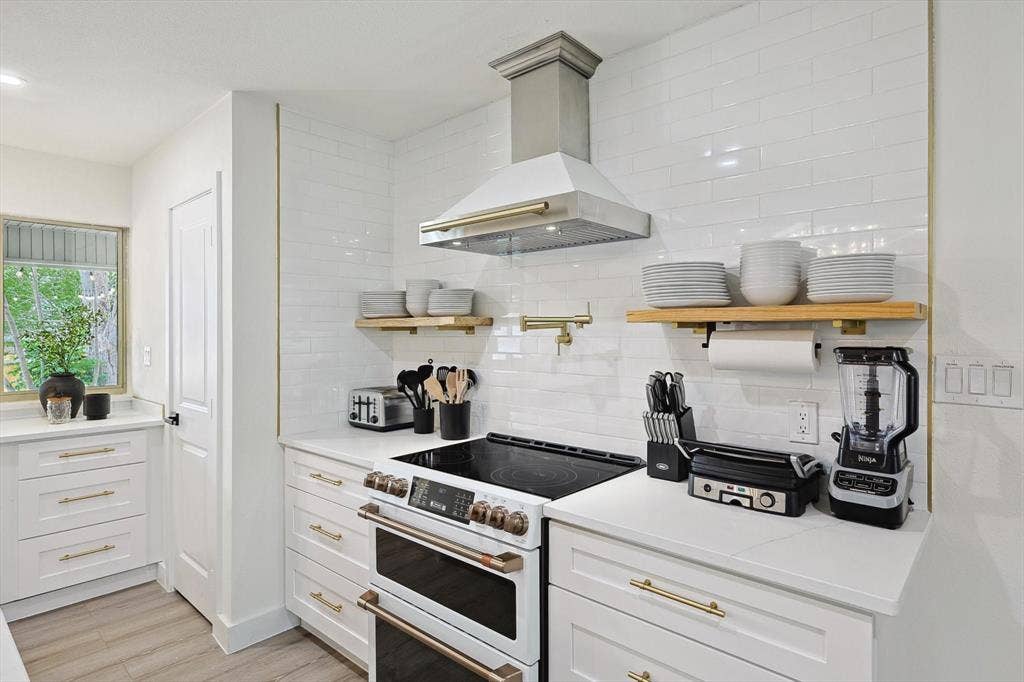 1208 Mayleaf Drive, Irving, TX 75060 Modern kitchen featuring a stainless steel range hood, white subway tile backsplash, and light wood-finish flooring