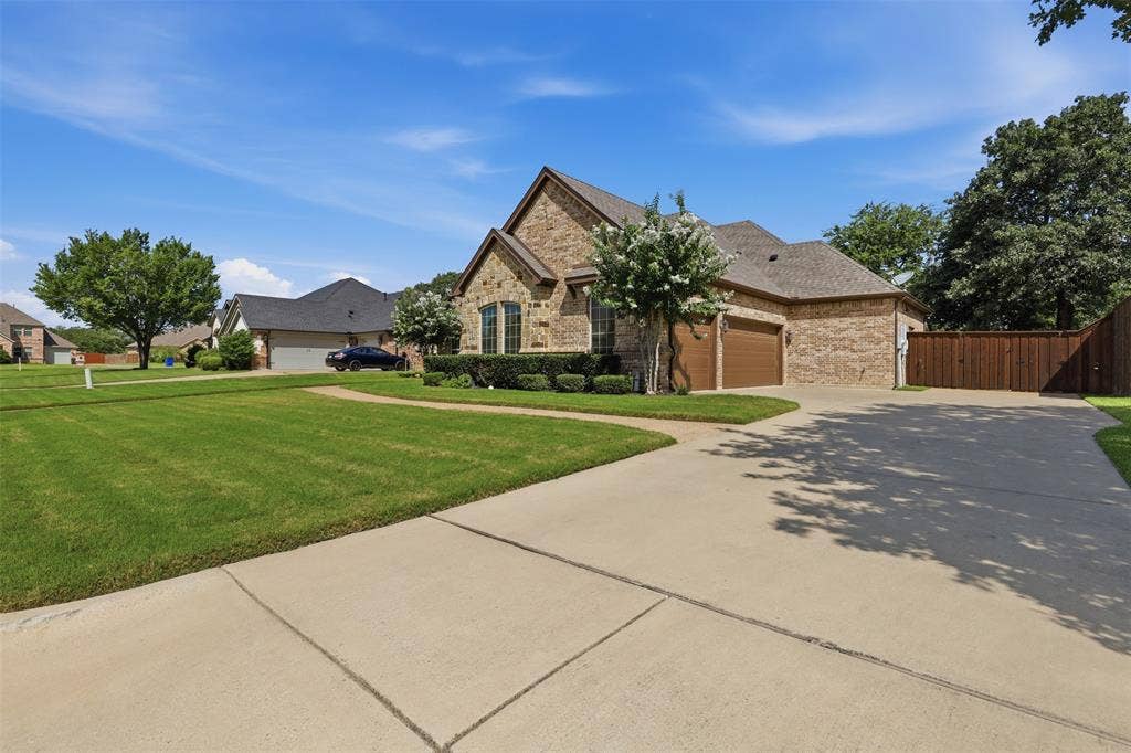 Brick exterior with arched windows and a multi-car driveway