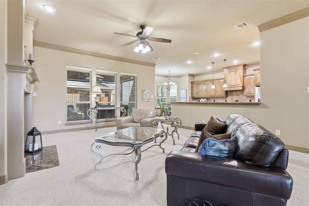 Spacious living area featuring a fireplace with a stone hearth, recessed lighting, and a ceiling fan