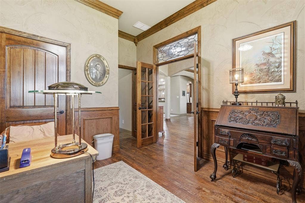 Interior space featuring wood-finish flooring, wainscoting, and crown molding