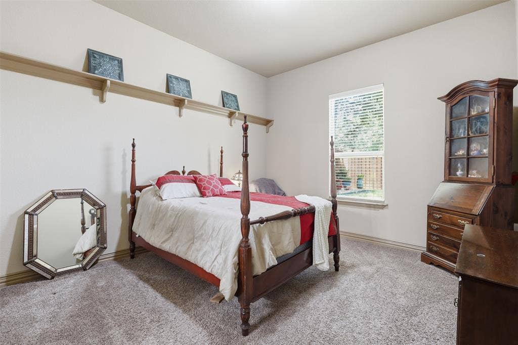 Carpeted room with a single window featuring horizontal blinds