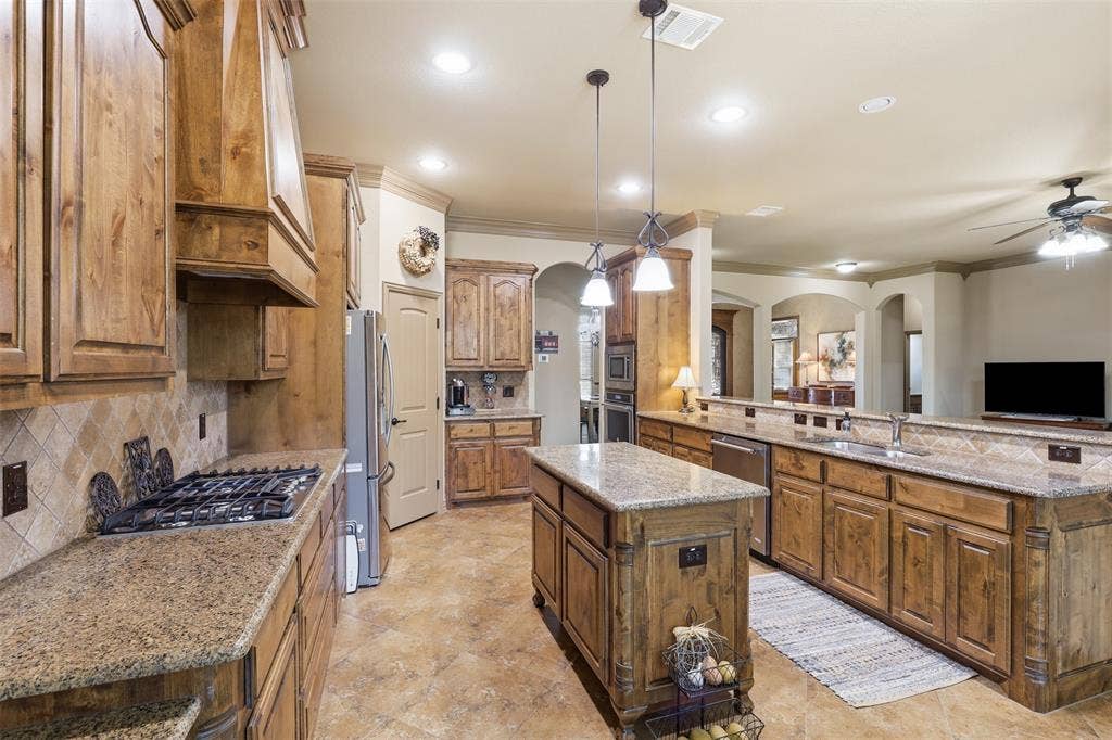 Expansive kitchen featuring custom wood cabinetry and granite countertops