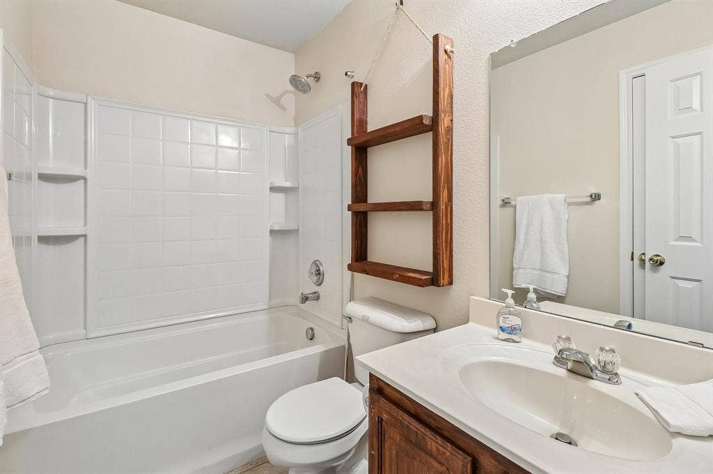 Bathroom featuring a white tub and shower combination with an integrated tile-patterned surround
