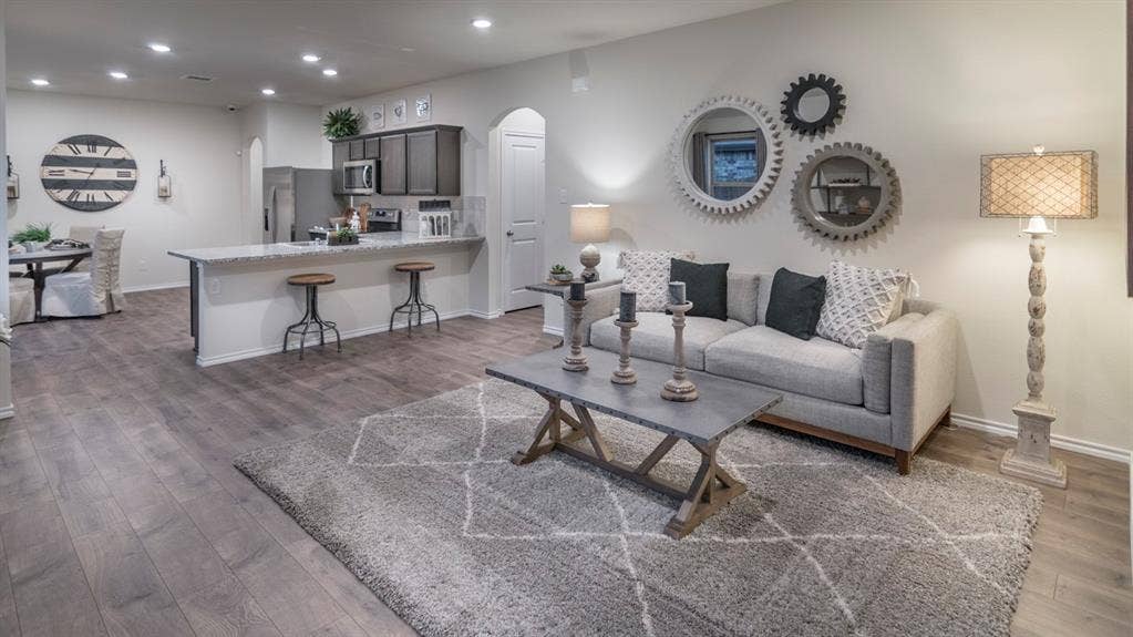 5618 Gannet Place, Crandall, TX 75114 Open-concept living space featuring wood-finish flooring, recessed lighting, a kitchen island with seating, a built-in microwave, and arched doorways