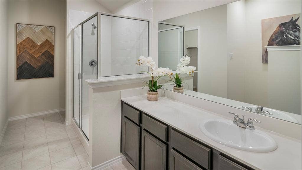 5618 Gannet Place, Crandall, TX 75114 Bathroom featuring a spacious vanity with an undermount sink, a full-width mirror, a glass-enclosed shower, and light-colored tile flooring
