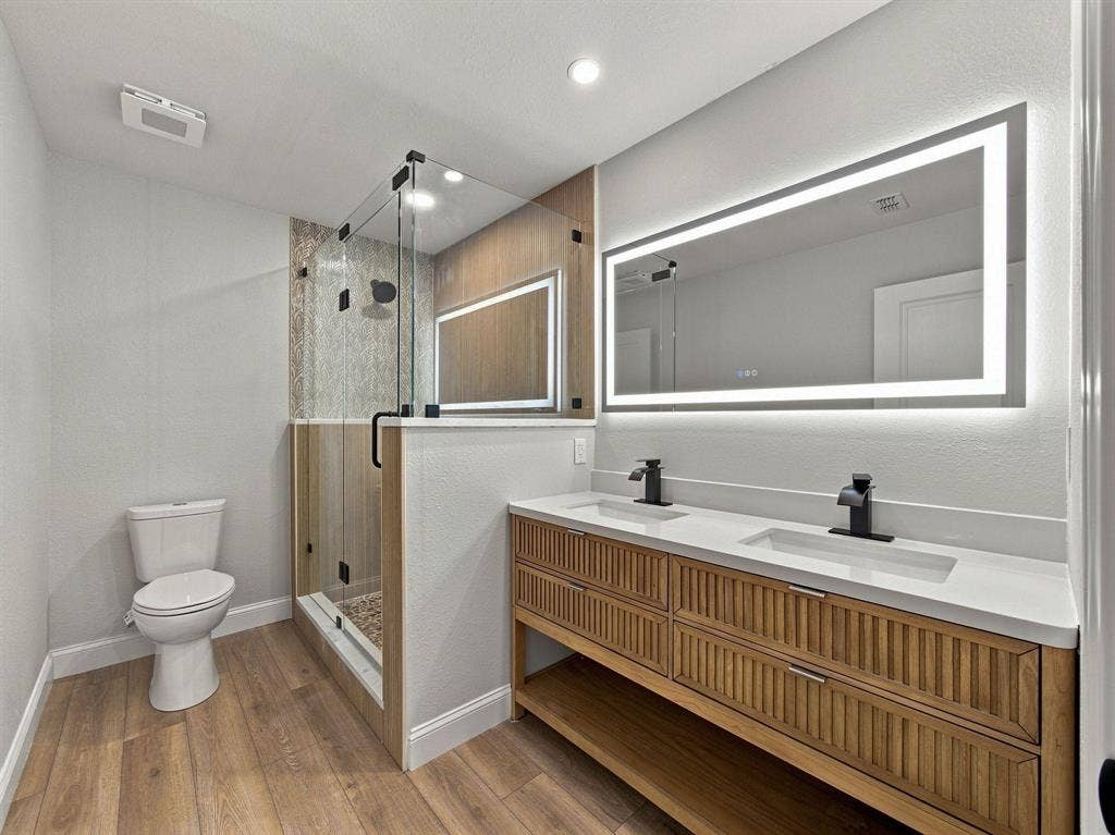 105 E Foggle Street, Athens, TX 75751 Primary Bathroom with lit mirror turned on