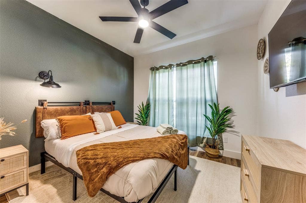 1116 Muncie Avenue, Dallas, TX 75212 Bedroom featuring a ceiling fan with integrated lighting, a window with light-filtering curtains, and wood-finish flooring