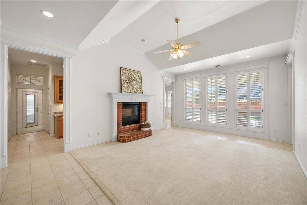 1013 Brook Arbor Drive, Mansfield, TX 76063 Formal living room has a fireplace, plantation shutters and overlooks the backyard.