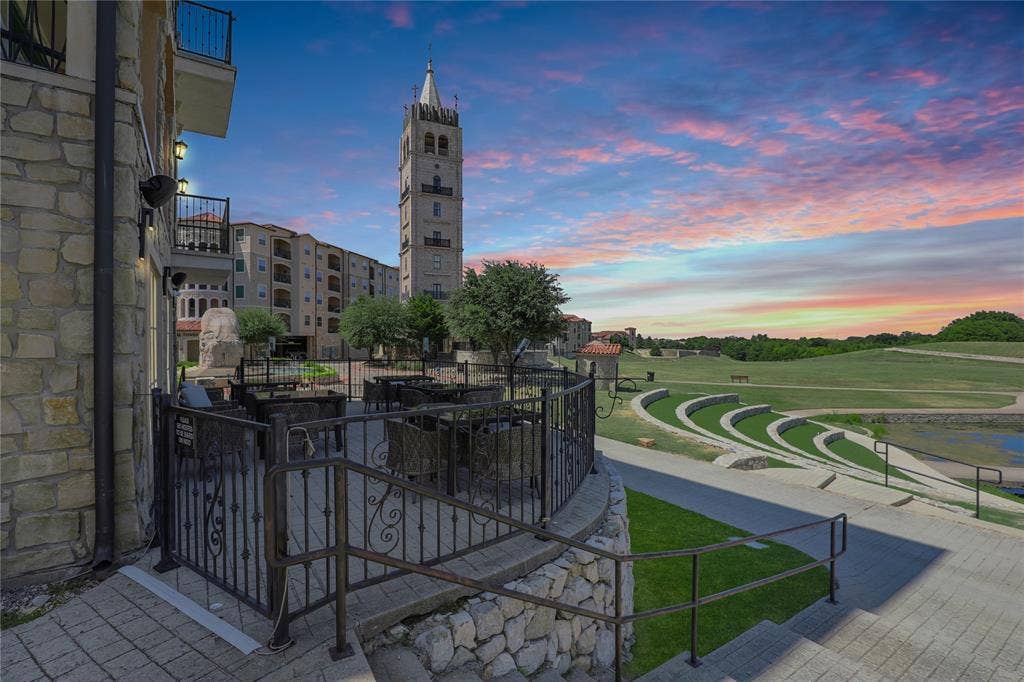 6601 Mediterranean Drive, #6101, McKinney, TX 75072 Patio area featuring stone walls, wrought iron railings, and a prominent bell tower