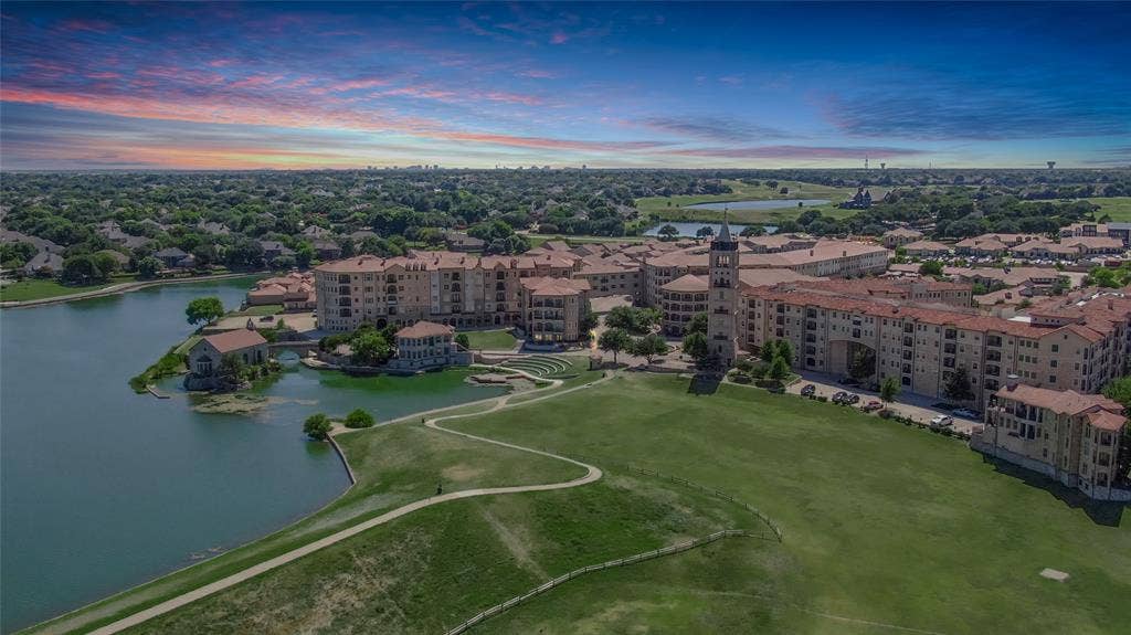 6601 Mediterranean Drive, #6101, McKinney, TX 75072 Extensive green space bordering a body of water, surrounded by multi-story structures featuring stone facades and terracotta-style roofing