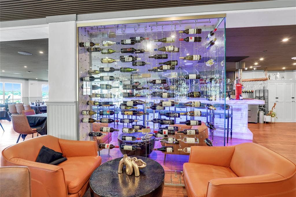 6601 Mediterranean Drive, #6101, McKinney, TX 75072 Custom glass wine wall with backlighting, hardwood-style flooring, white wainscoting, and recessed lighting