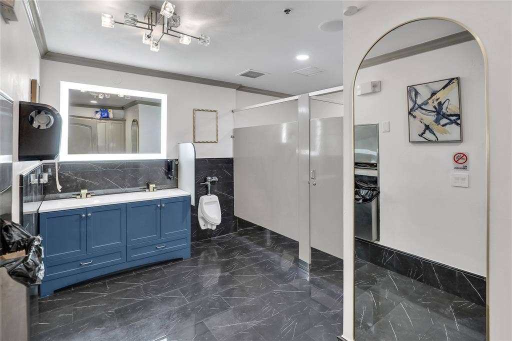 6601 Mediterranean Drive, #6101, McKinney, TX 75072 Spacious restroom featuring dual vanity with blue cabinetry, white countertops, and gold-finish faucets