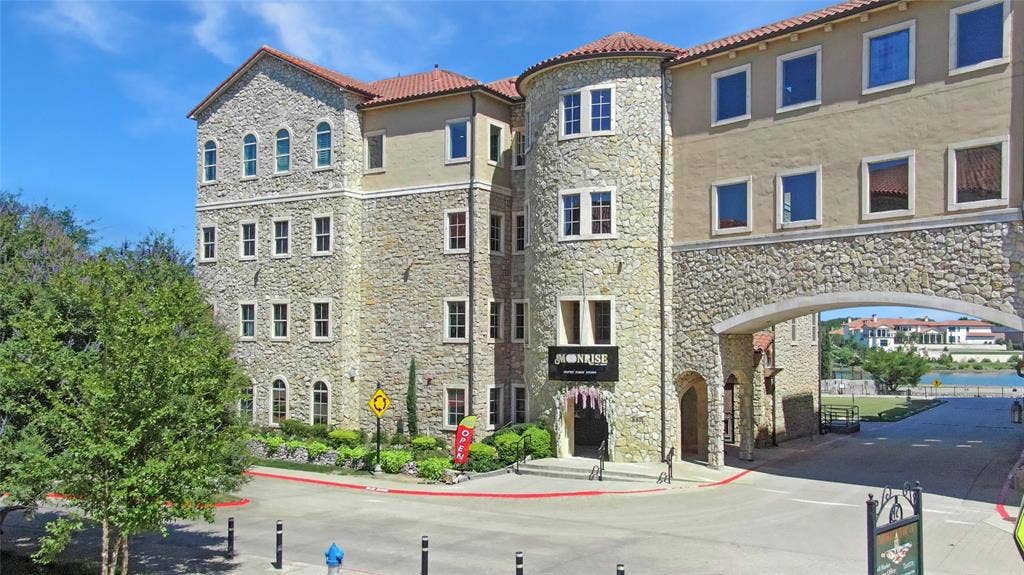 6601 Mediterranean Drive, #6101, McKinney, TX 75072 Multi-story building featuring stone and stucco exterior, arched windows, and a terracotta tile roof