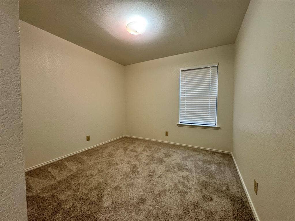 2812 Howard Court, Denton, TX 76209 Carpeted room with a single window featuring horizontal blinds