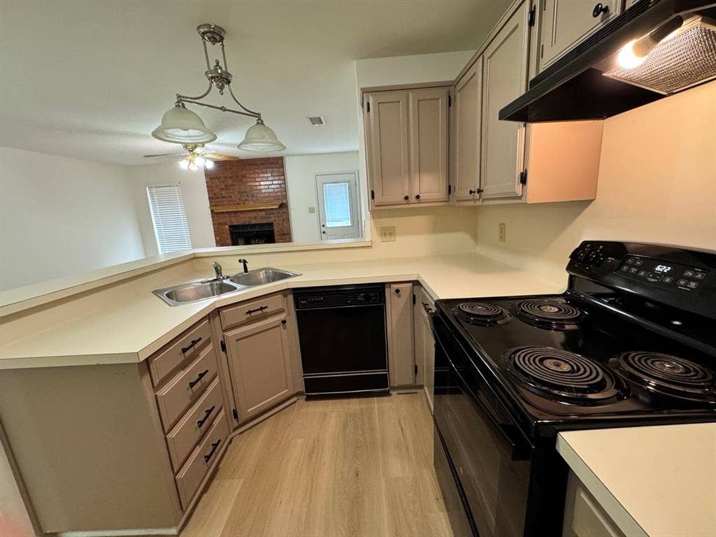 2812 Howard Court, Denton, TX 76209 U-shaped kitchen featuring wood-finish flooring, light-toned countertops, and painted cabinetry with dark hardware