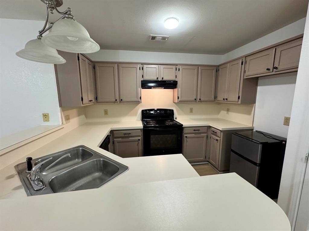 2812 Howard Court, Denton, TX 76209 U-shaped kitchen featuring light-toned cabinetry with dark hardware and a dual basin stainless steel sink